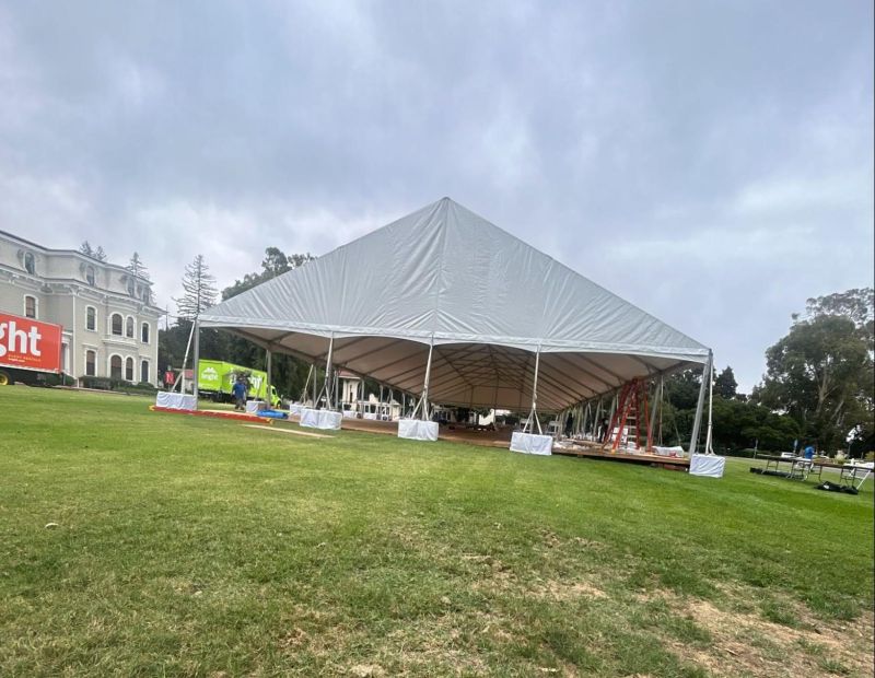 Large white frame tent as a temporary shelter option for dining, vendor, or staging areas.