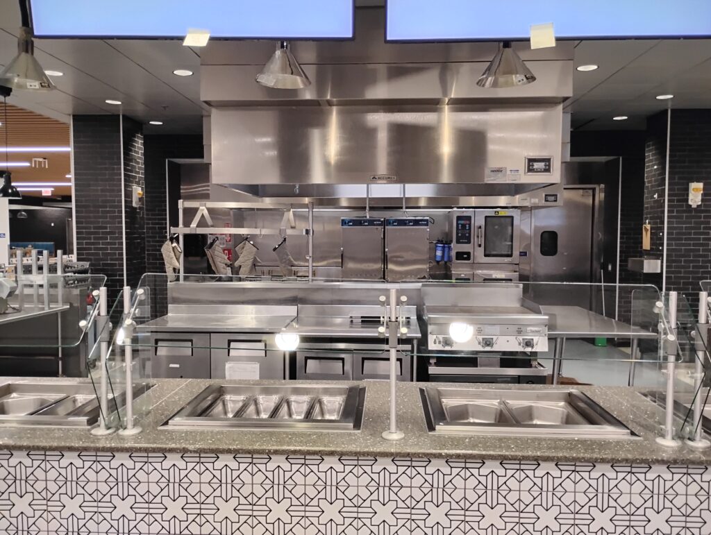 Commercial kitchen cook line and ventilation hood organized by cleaning zone