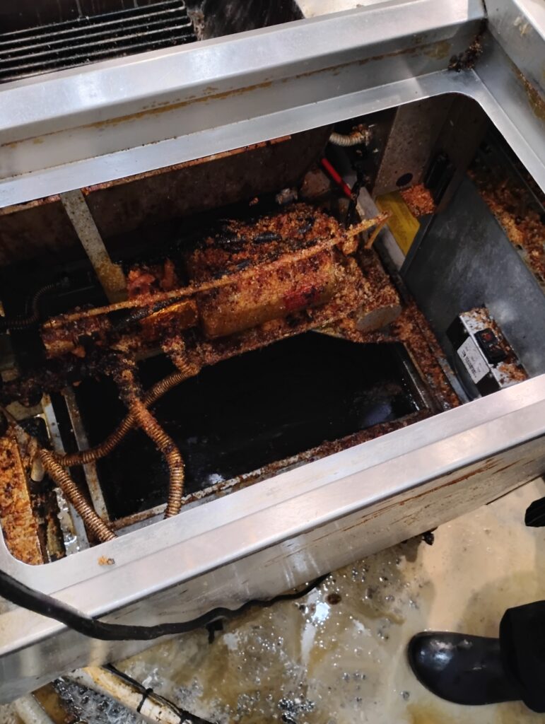 Grease buildup in a commercial kitchen grease trap requiring professional cleaning