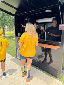 Guest ordering at the service counter of a black container bar