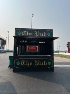 Black container bar branded The Pub in a stadium parking lot