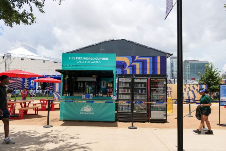 Teal branded container bar with drink coolers beside picnic seating